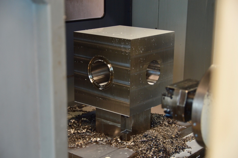 Water sprays on an API studded block inside a CNC machine